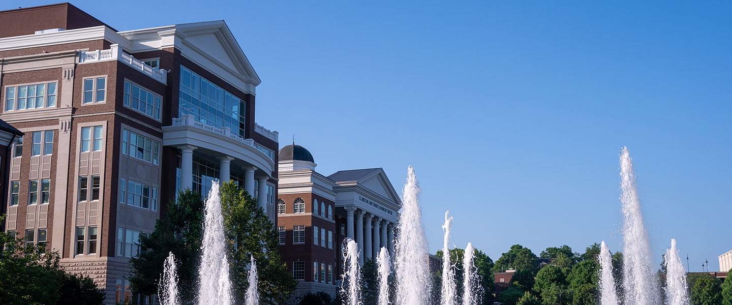 Building on campus and water fountain in foreground