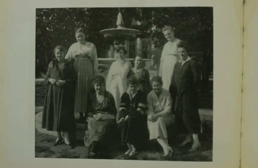Photo of a group of female students standing outside in front of a fountain