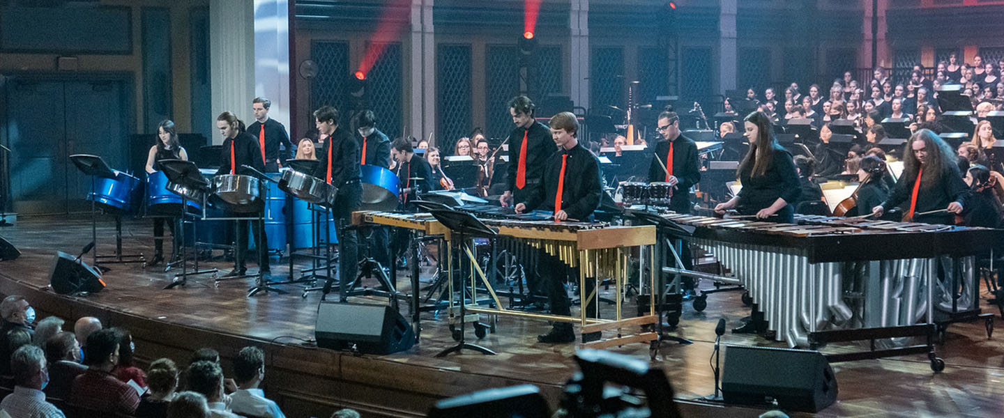 A percussion ensemble performs on stage.