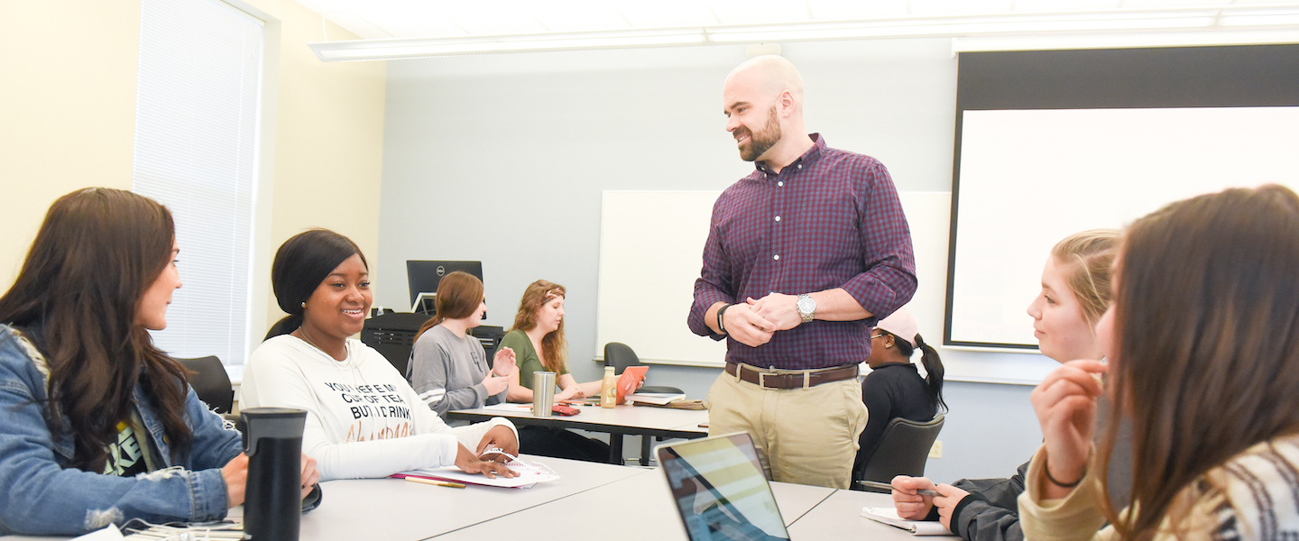 Professor teaches class with communication studies students