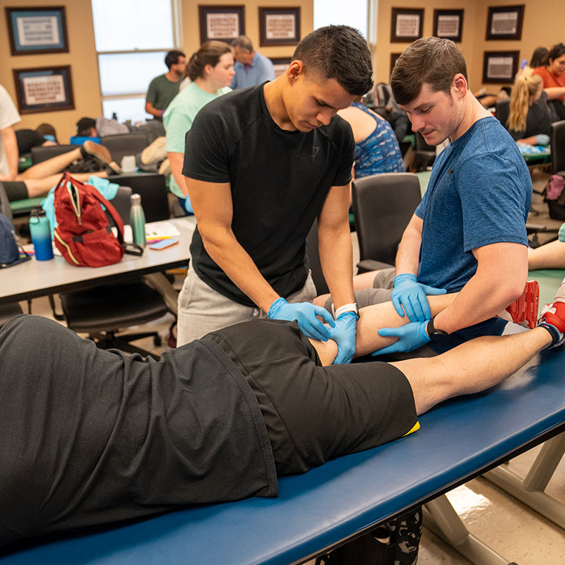 Two Physical Therapy Students working with a patient