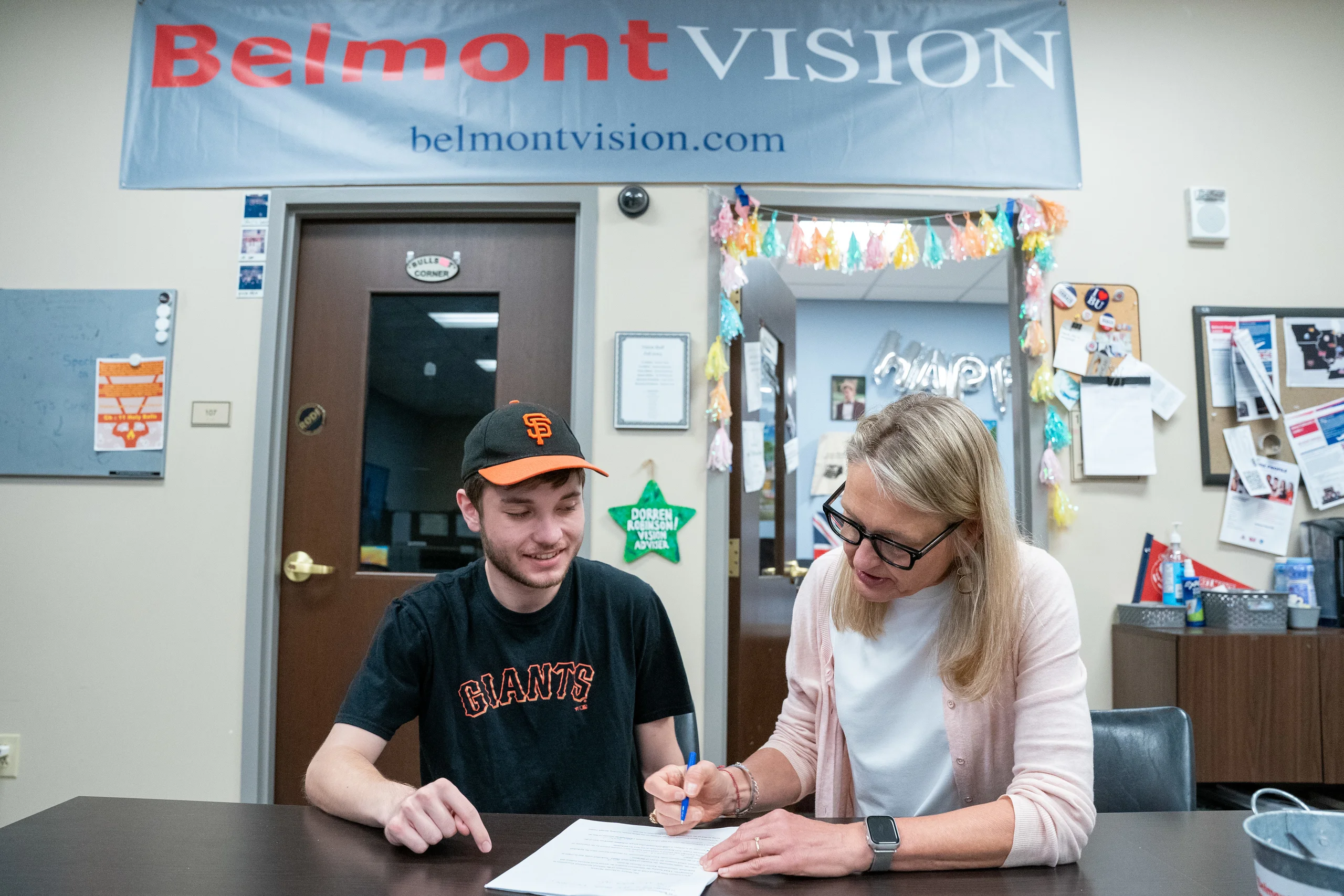 Student and Professor of Journalism working on paper for Belmont Vision, student publications.