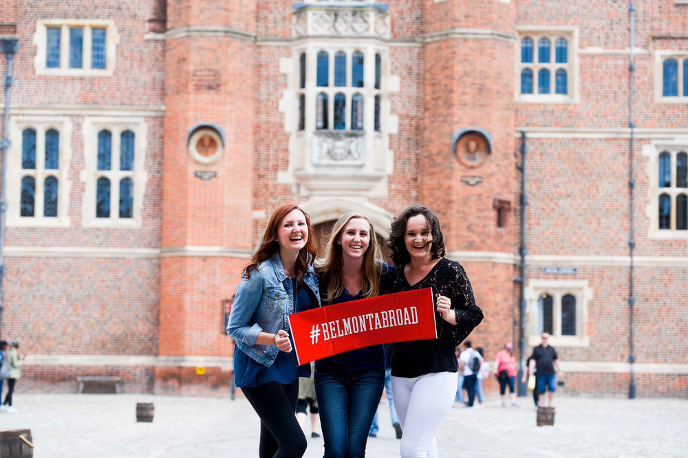 students holding a red sign that says belmont abroad