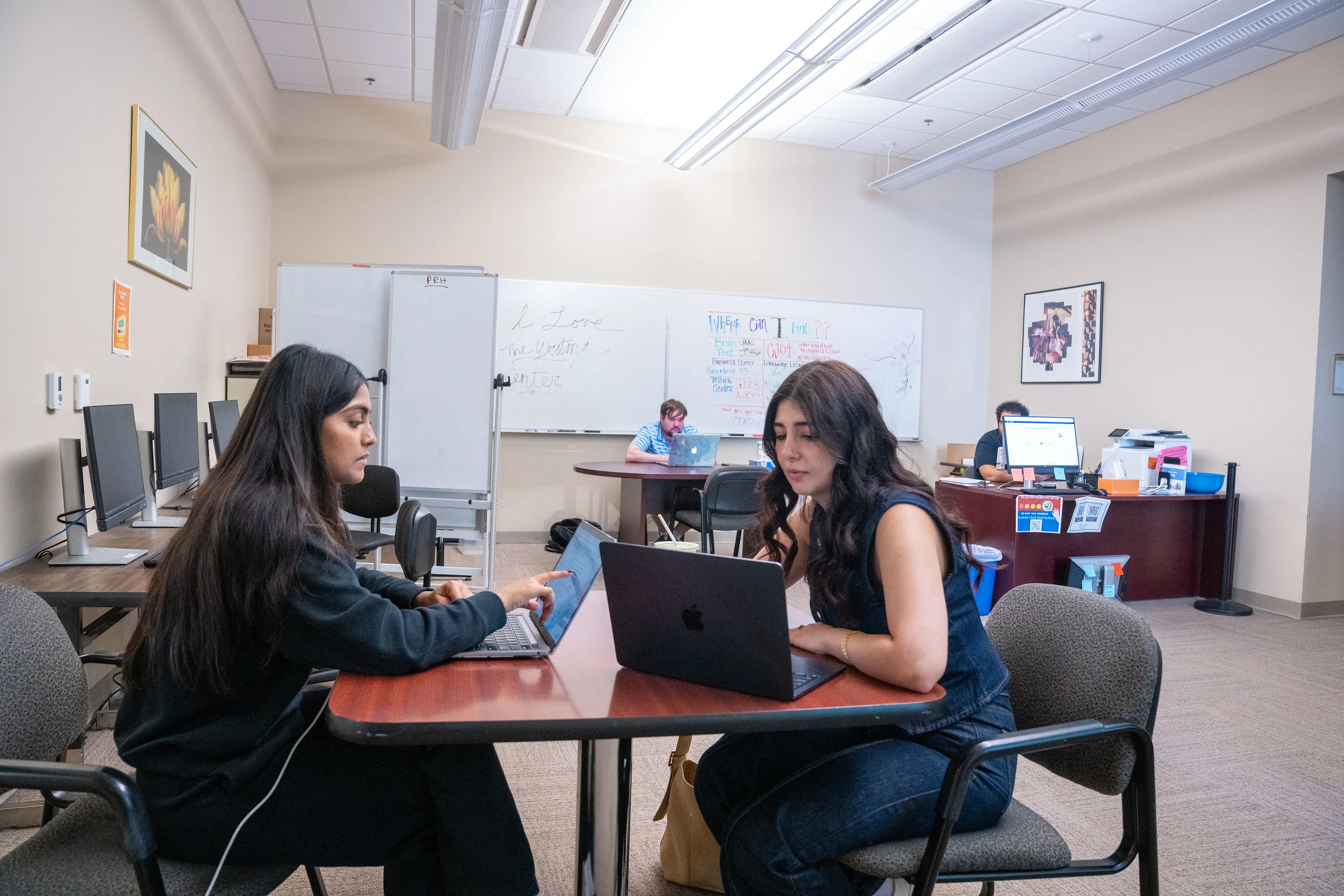 Two women collaborate on laptops in Belmont Writing Center.