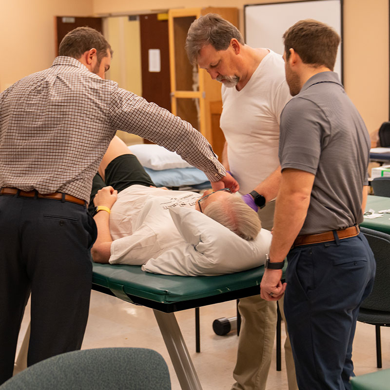 Physical therapy students work with a patient