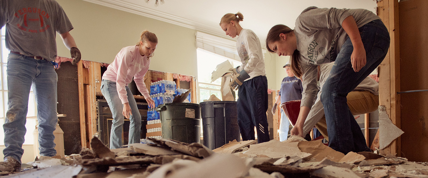 A team of students work to clean up a warehouse.