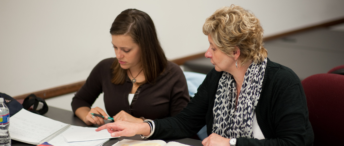 A student sits with a faculty member learning German