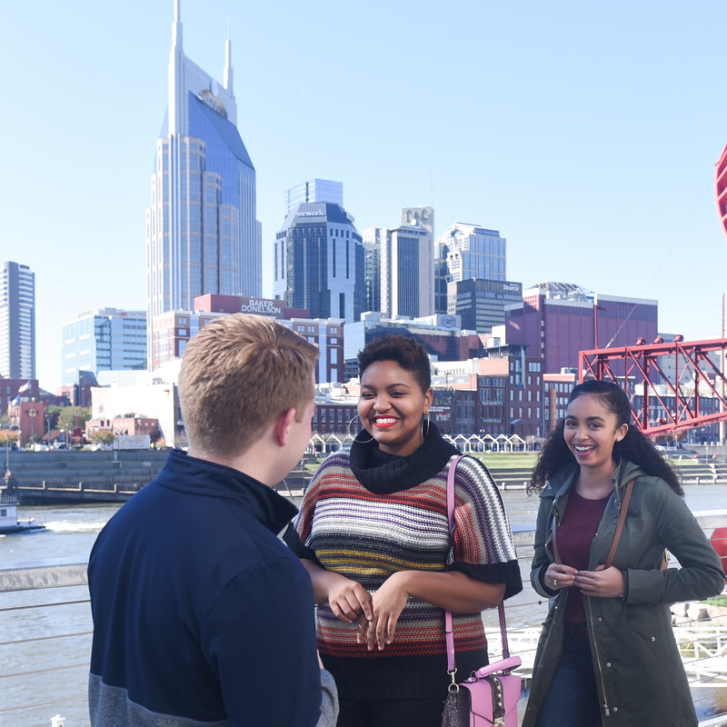 Students talking outside with the Nashville skyline behind them