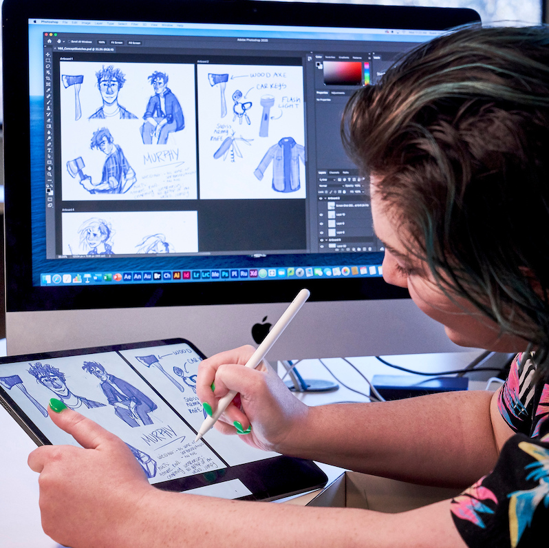 Student Illustrating art work on a digital tablet in design lab