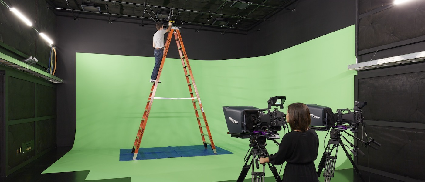 Students in front of green screen with camera.