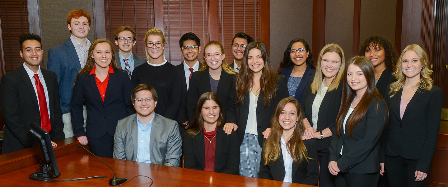 A group of legal studies students pose in the mock trial room.