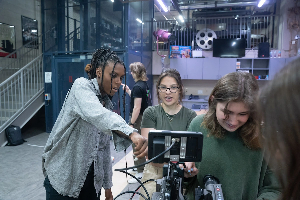 students surrounding camera