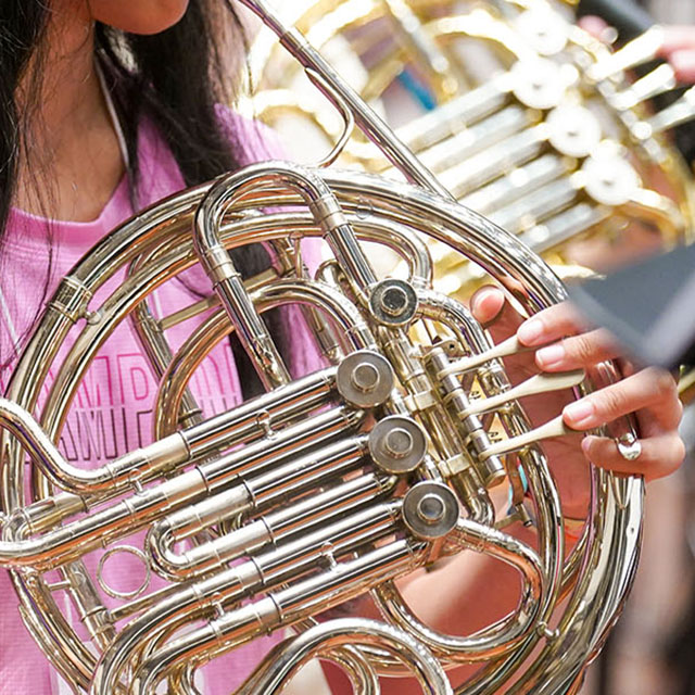 Close up of student playing the french horn