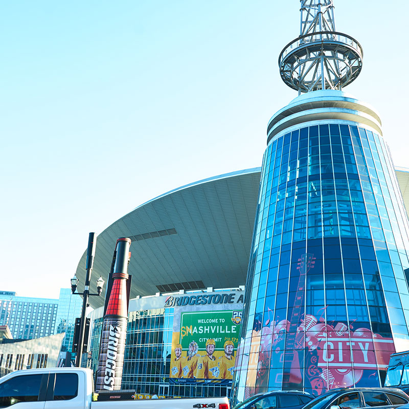 A view of Bridgestone Arena in Nashville, Tennessee, featuring its distinctive glass tower and signage.
