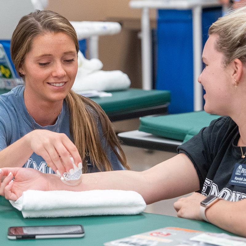 Two occupational therapy students working with ice in a lab