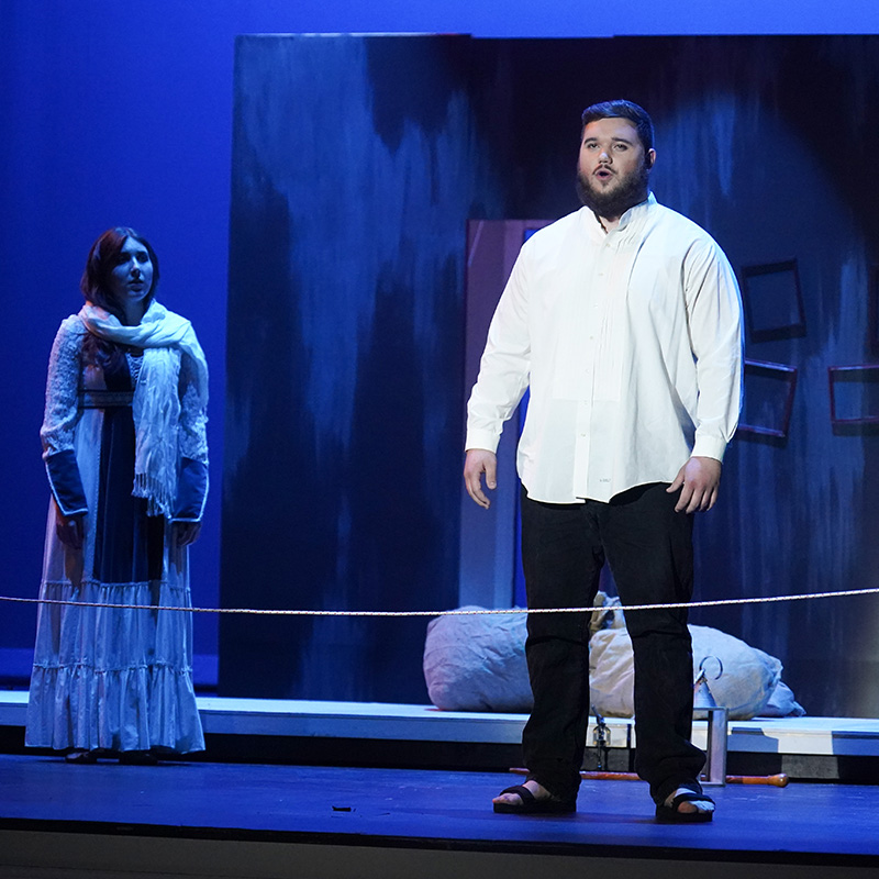 A male student sings opera on stage.
