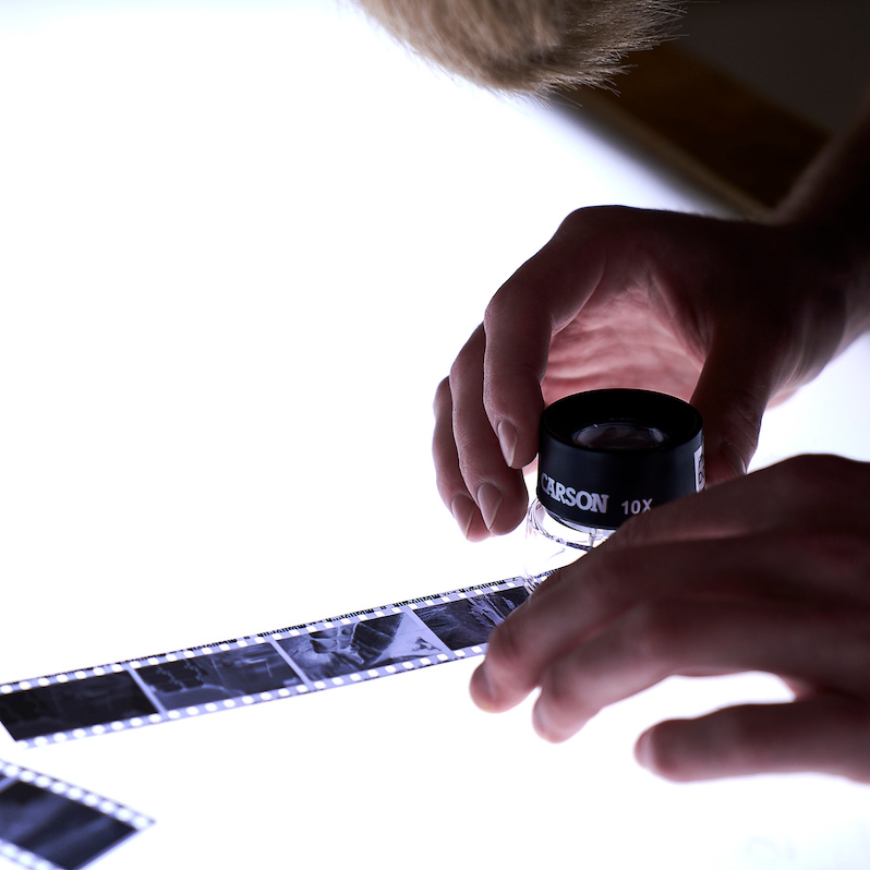 Close up of student looking at photo negatives on light table