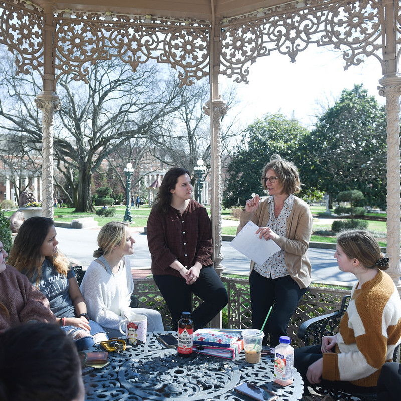 Social work students have class outside in a gazebo
