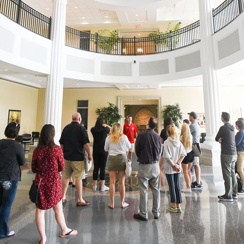 A campus tour walks through the Janet Ayers Academic Center Atrium