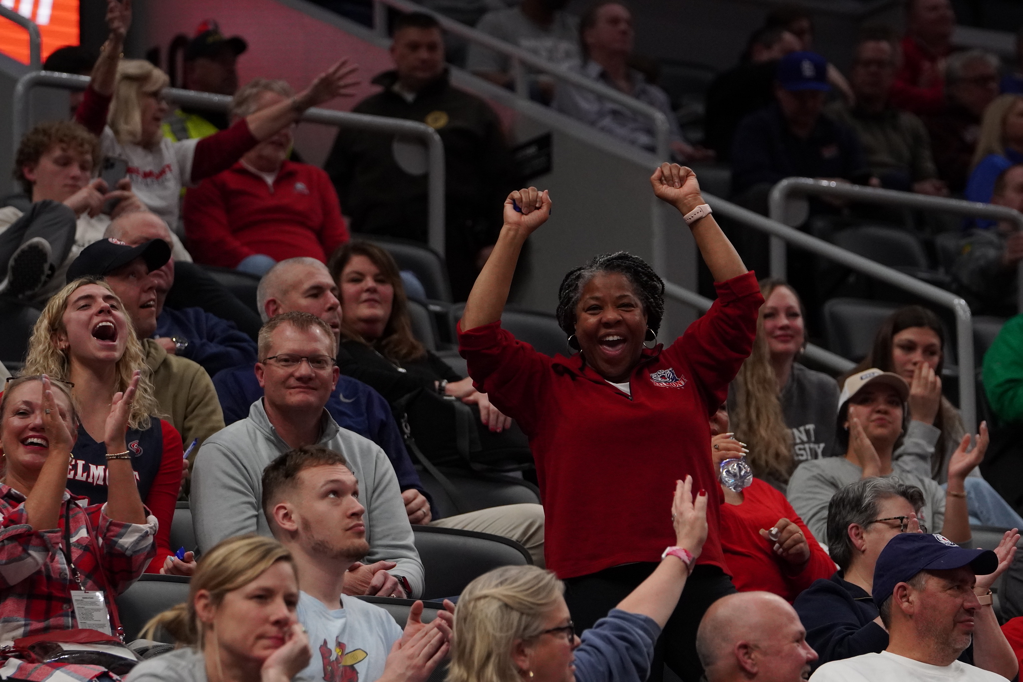 A woman cheers in the stands at a Belmont basketball game.