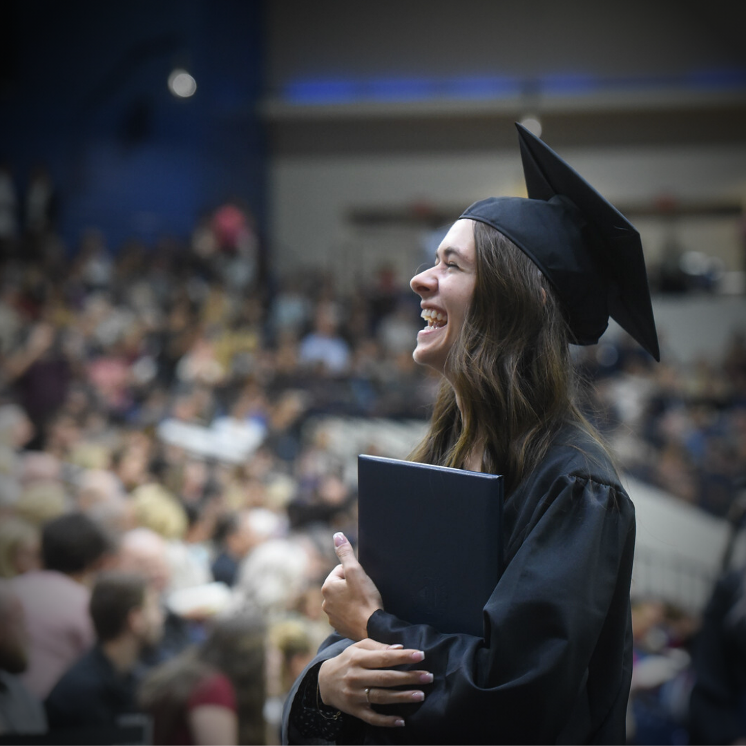 A female Belmont student smiles at her graduation ceremony.