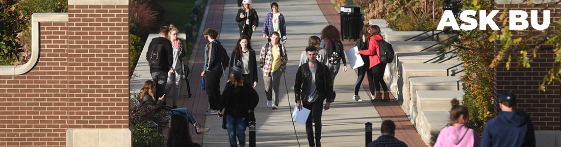 A photo of students walking down a side walk with ASK BU in the top right corner