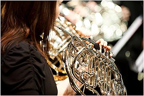 Close up of girl playing the french horn in the Belmont concert band