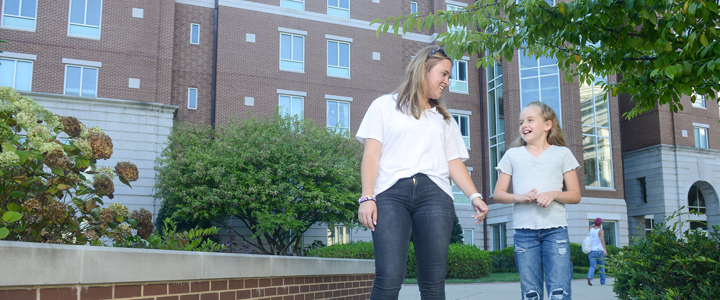 A Belmont education student walks with an elementary age girl through campus.