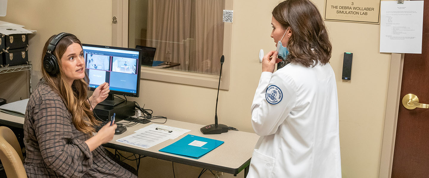  A professor gives feedback to a student during a patient simulation