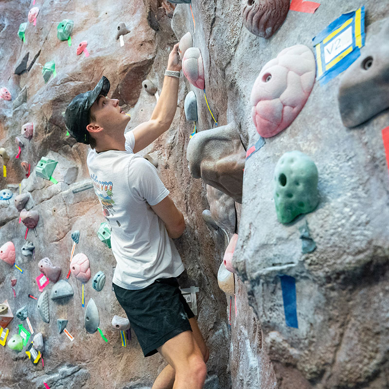 A student climbing the rock wall