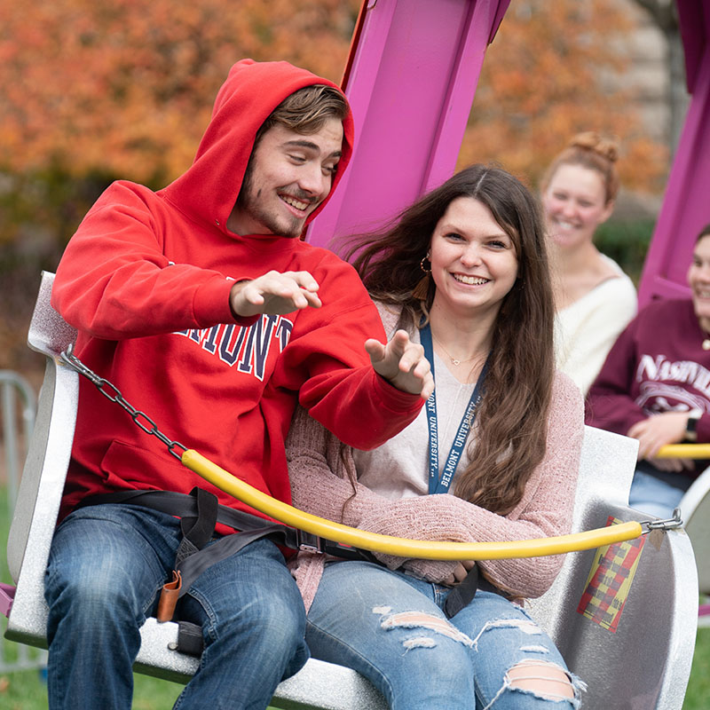 Two students riding a swing ride at Hope Summit