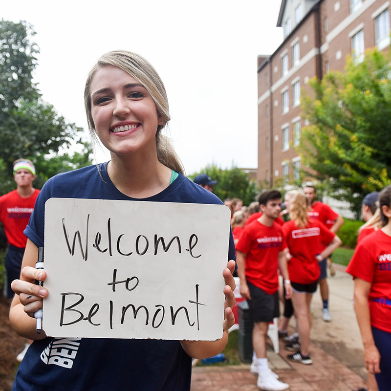 A student holding a sign saying Welcome to Belmont