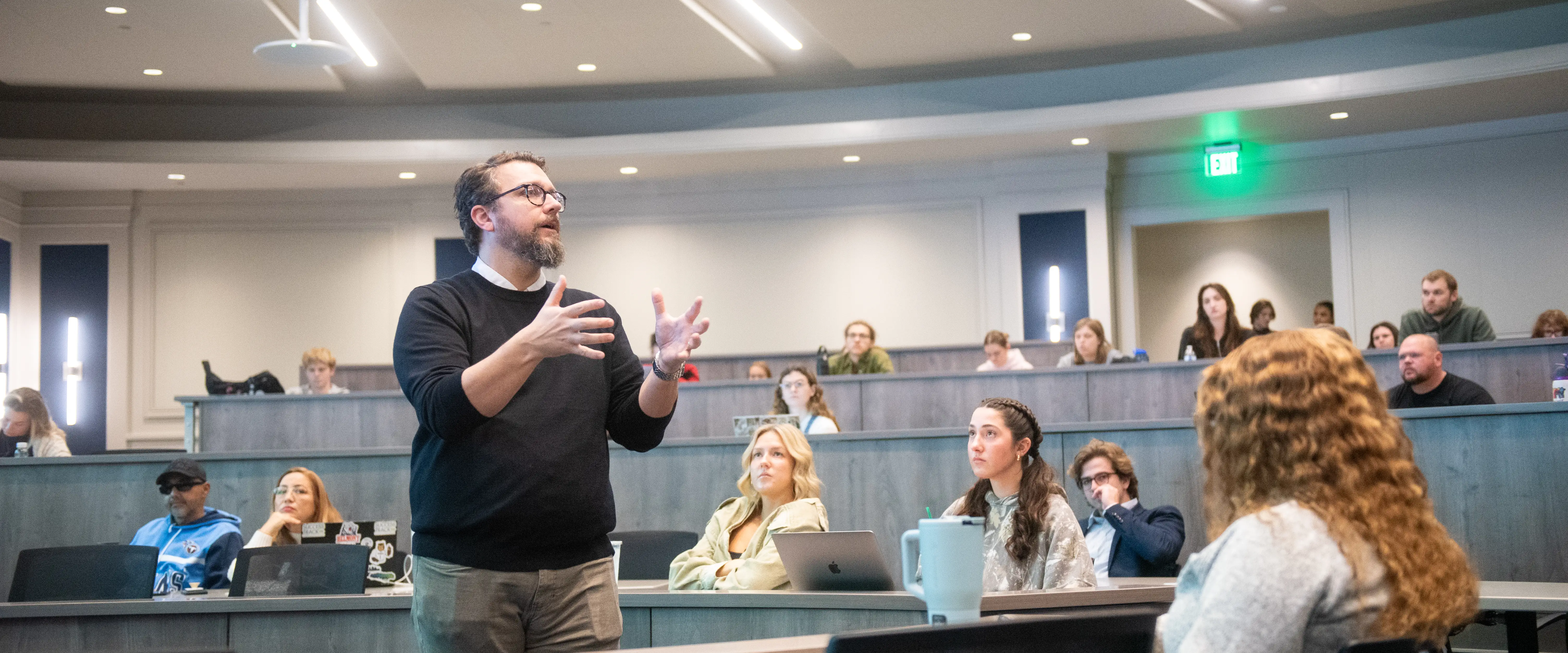 Economics professor Adam Fulton speaking with students