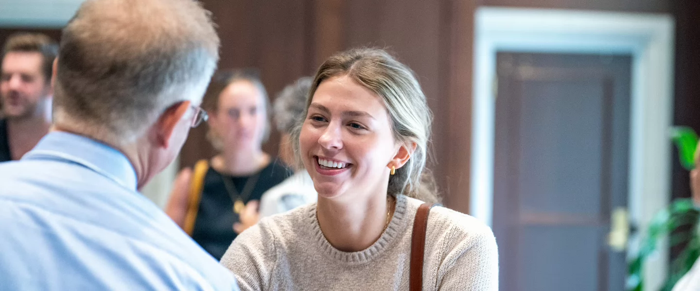 A Belmont University student smiles while talking with a faculty or staff member during the 24/7 Conference community gathering.