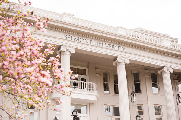 blooming trees in Spring in front of a tall building with Belmont University engraved at the top