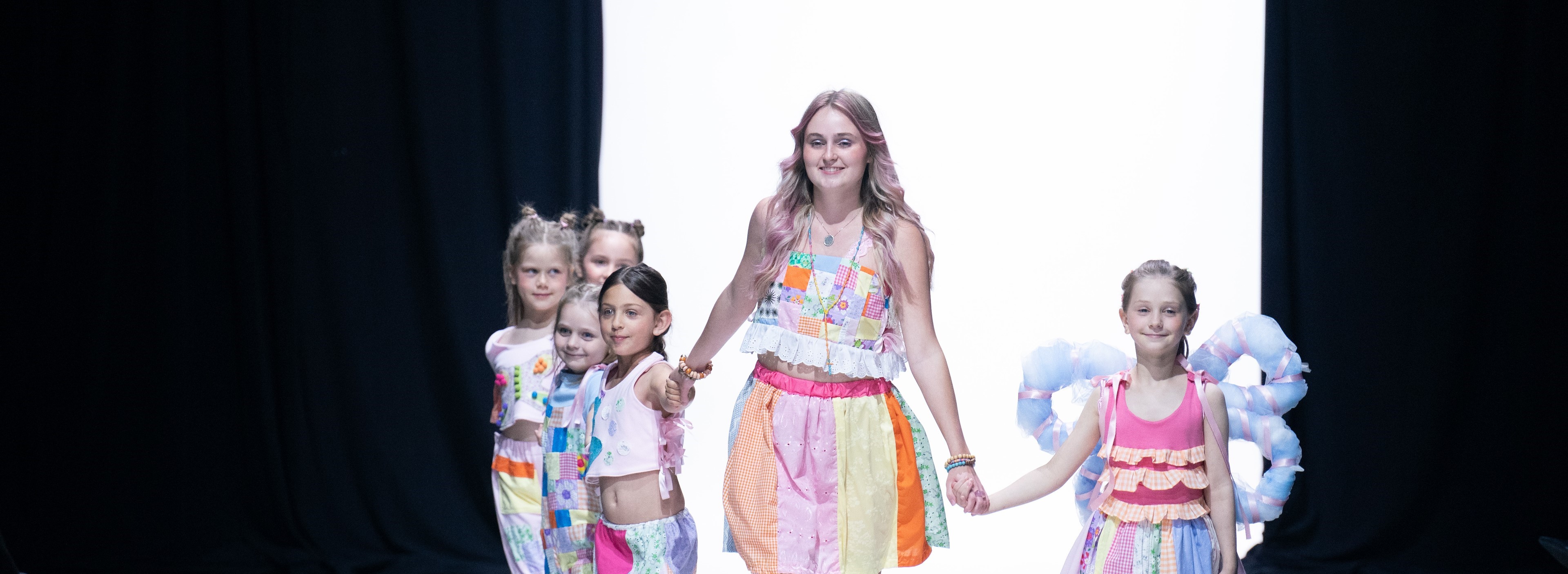 Fashion Design student walking child models down the runway
