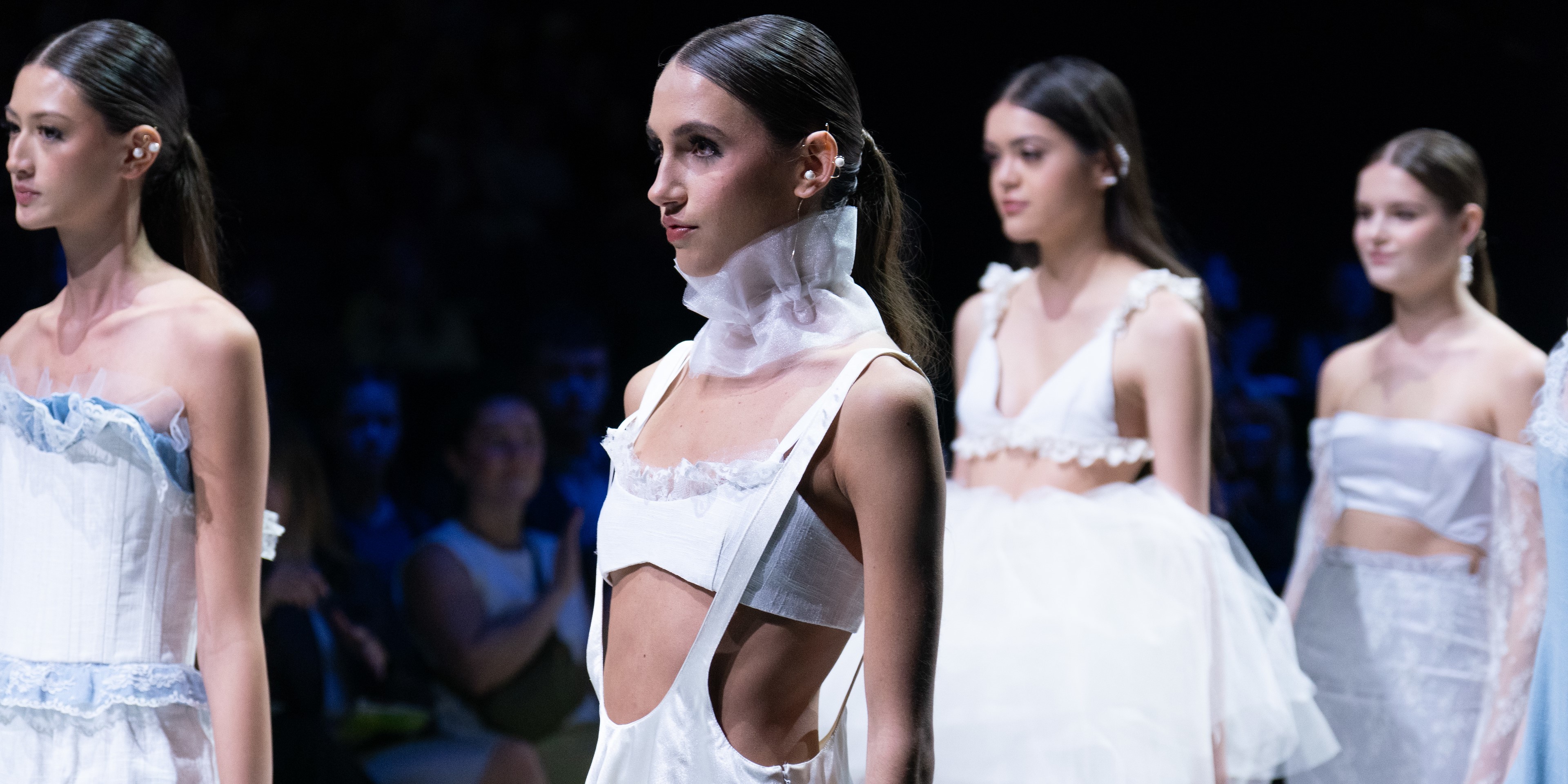 Models in white walking down the runway