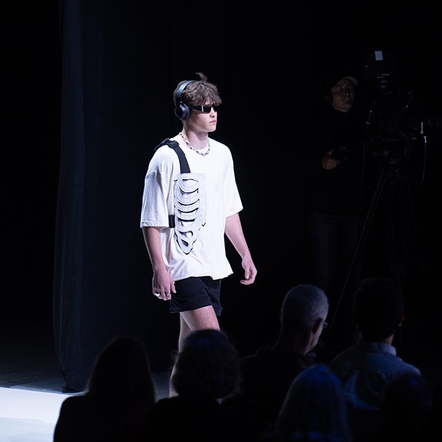 Male model walking on runway at fashion show