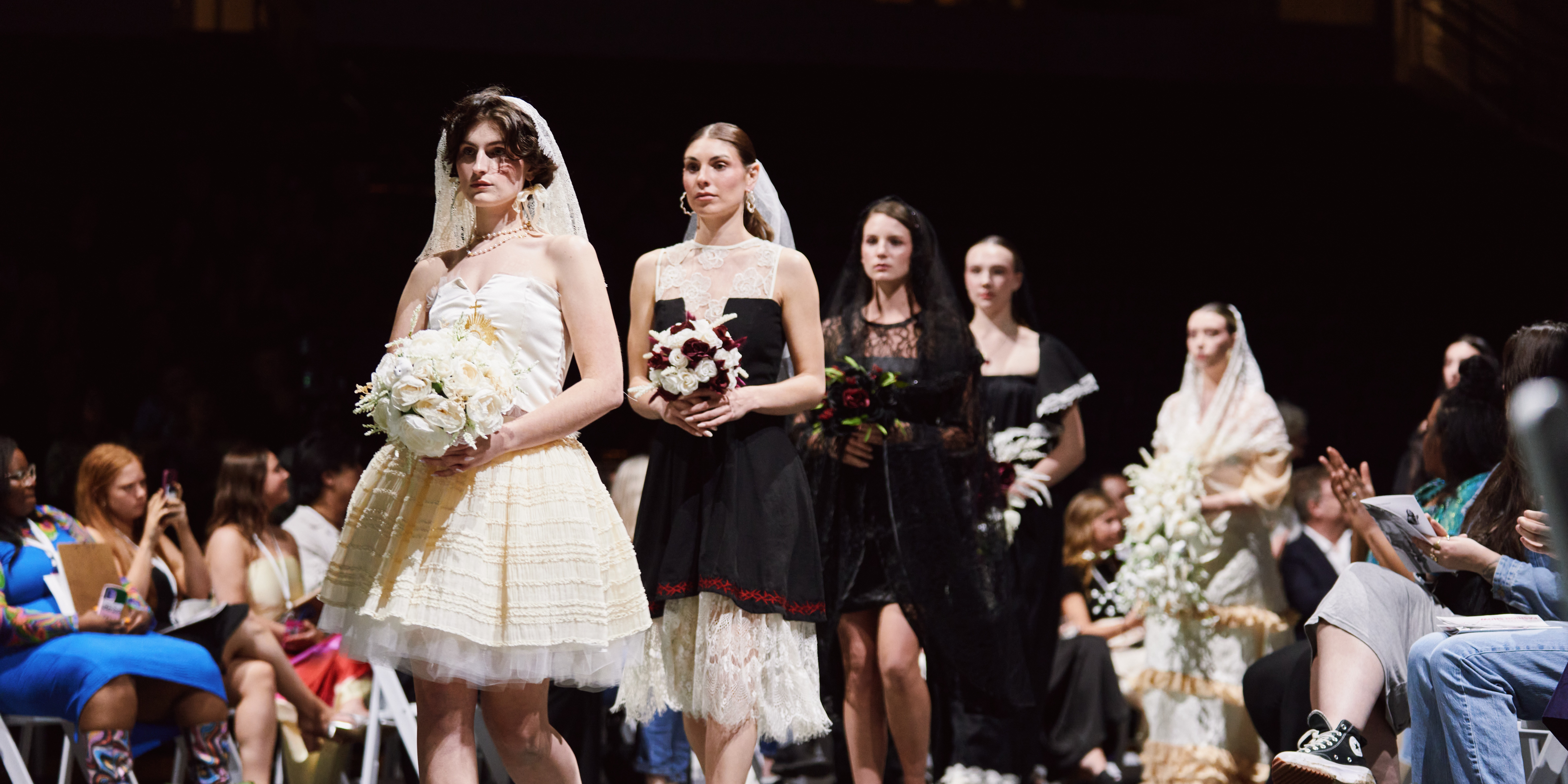 Models in white walking down the runway