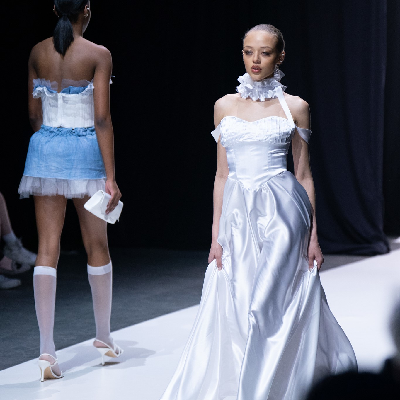 Female model walking on runway at fashion show