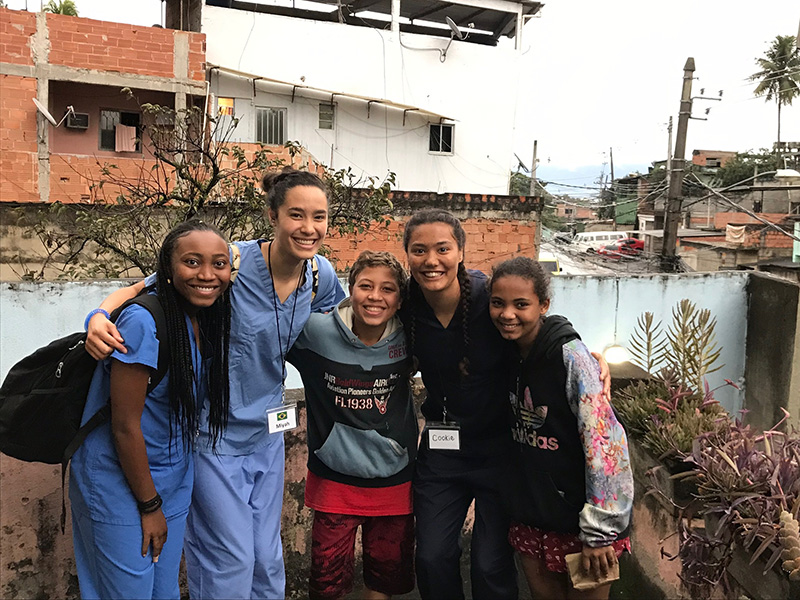 Medical Students smiling with small children in a different country.