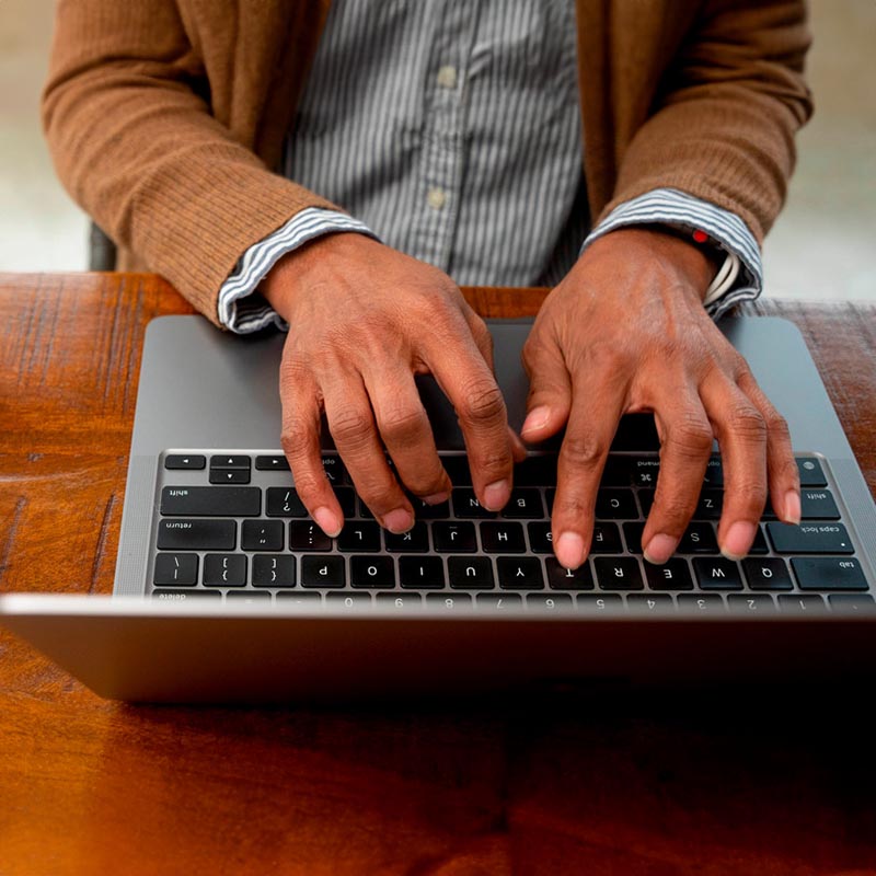 Above shot of woman's hands typing on a laptop