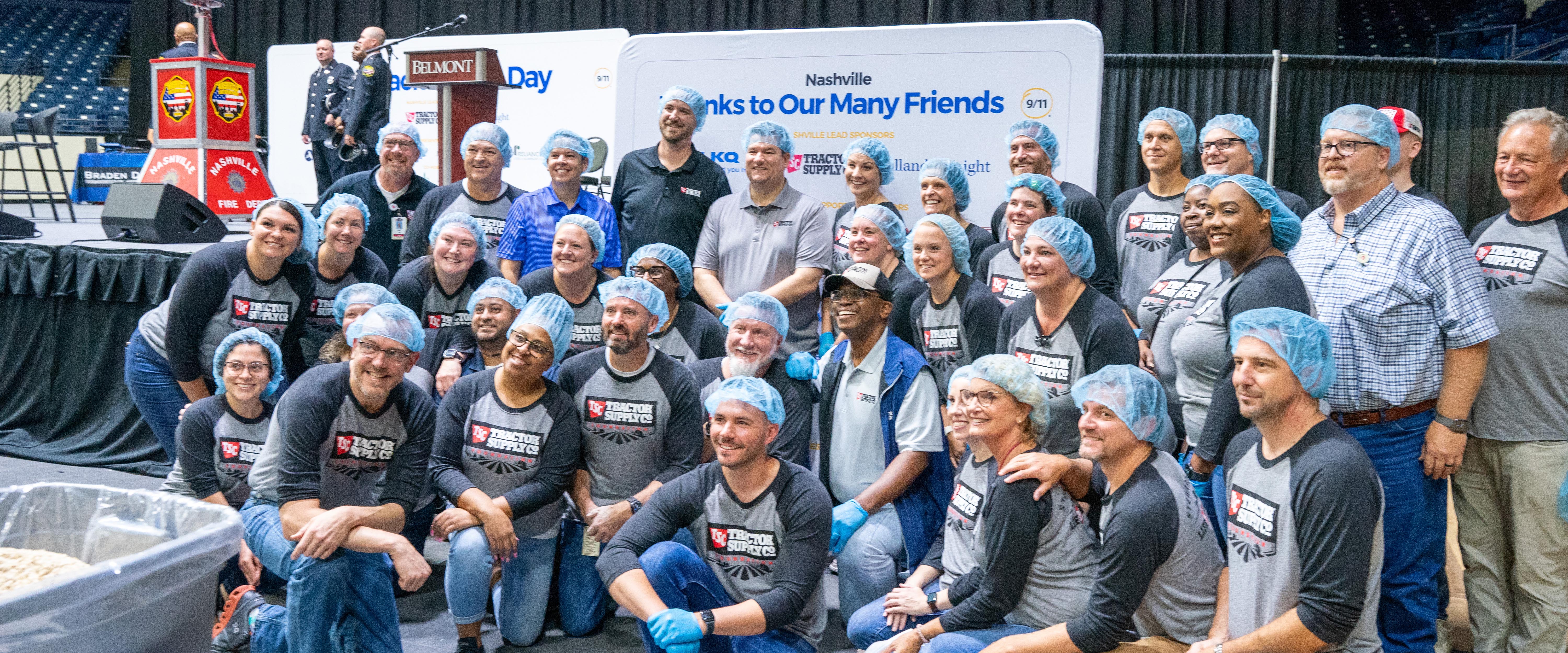 Belmont faculty and staff pose for a picture in hair nets and matching tshirts during Meal Pack for 9/11 Day.