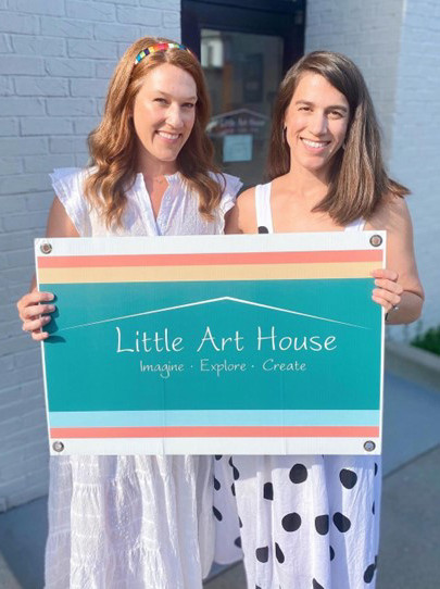 Emma Bradford and Leighton Lancaster holding a Little Art House sign