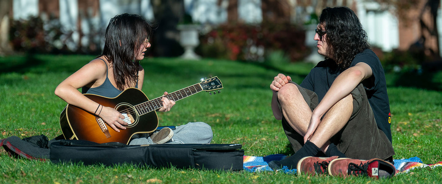 Two students playing music on Belmont's Quad