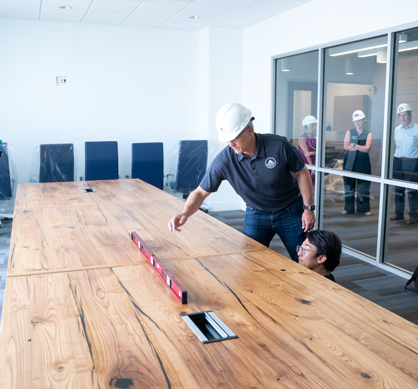 Dave Puncochar using level on conference table.