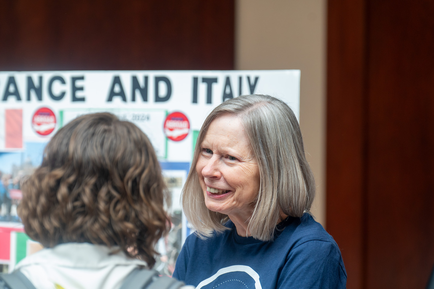 instructor stands in front of an Italy booth