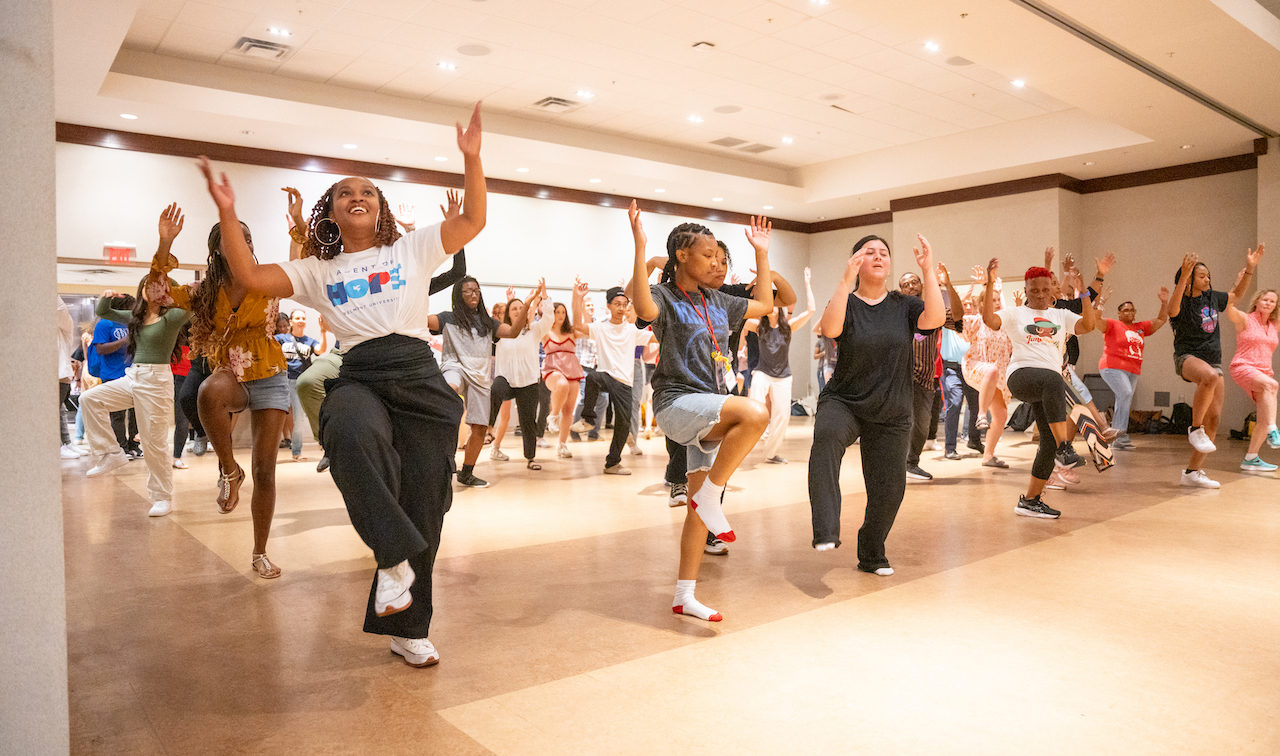 People raising their hands in the air and dancing