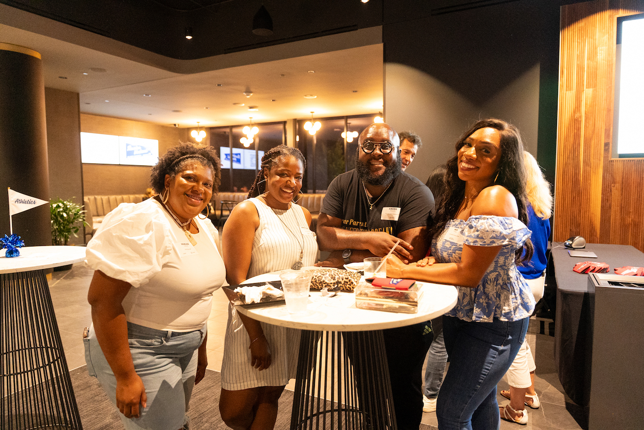 Four alumni pose for picture at Reunion Weekend kickoff