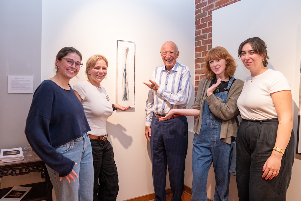 students pose with Knestrick in front of Red Grooms's portrait of him